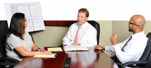 three professionals at conference table